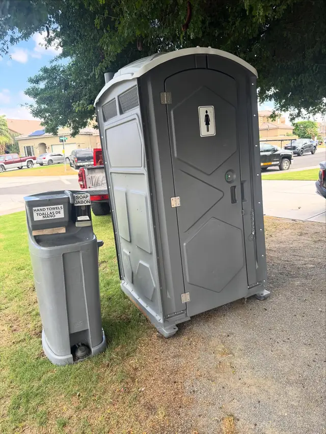 Two-sink handwashing station next to a porta potty